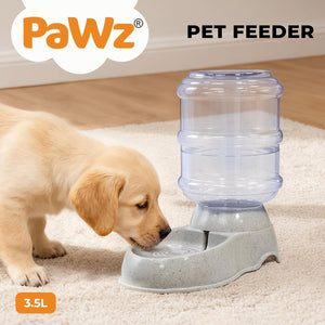 A small golden puppy drinking from a Pawz automatic pet feeder on a beige carpet. The feeder has a translucent blue water reservoir mounted on a gray base at Pet Servo