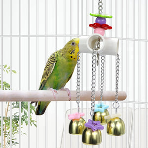 Bird perched on a branch with a colorful bird toy in a cage at Pet Servo