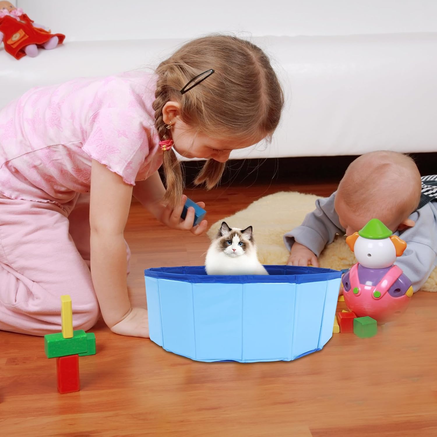 Child playing with a cat and toys on a wooden floor at Pet Servo