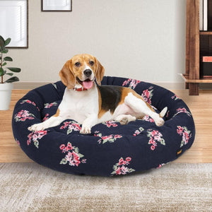 Dog lying on a floral-patterned dog bed in a home setting at Pet Servo