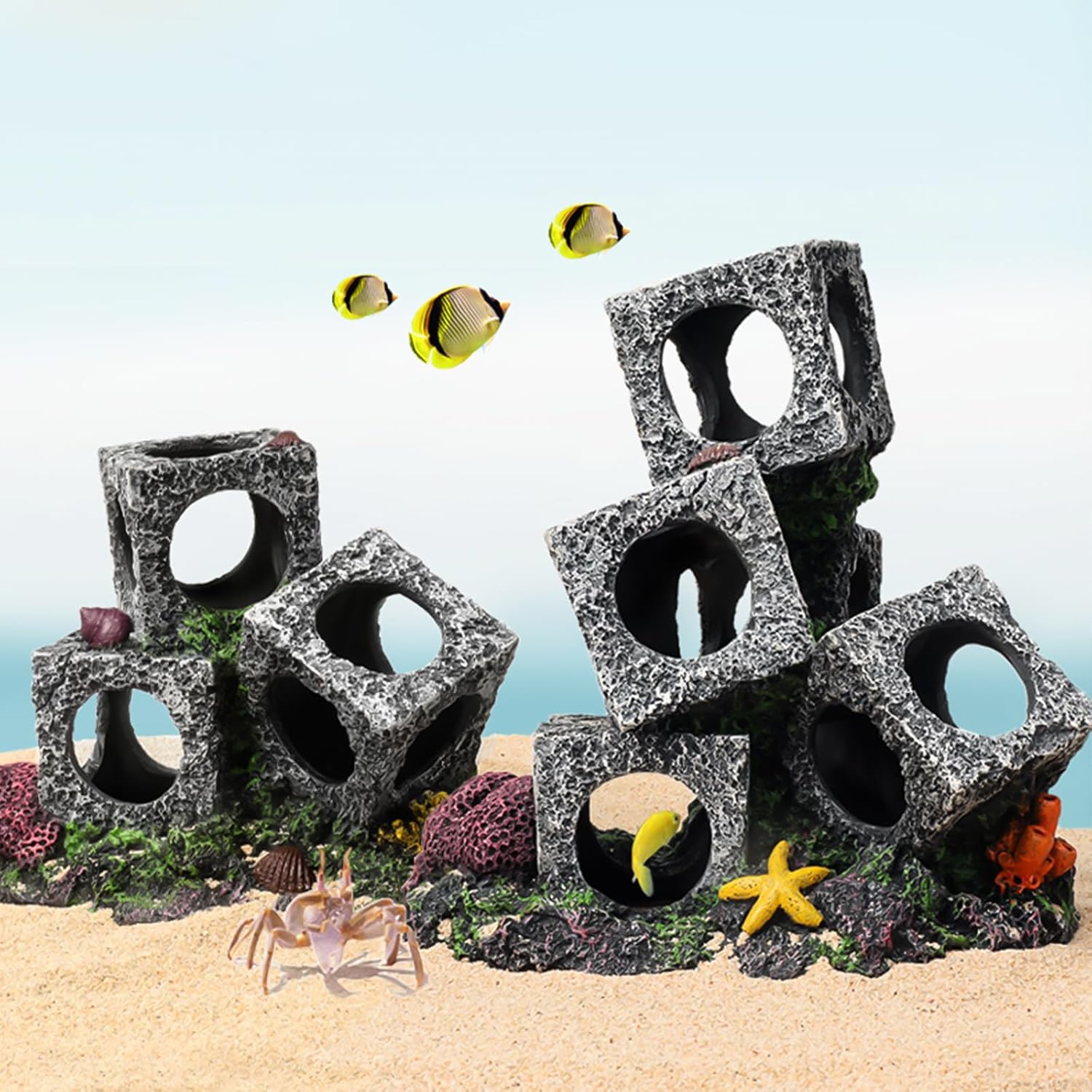 Aquarium decorations with stone blocks and marine life on a sandy bottom at Pet Servo