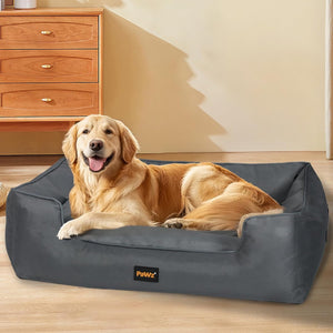 Dog lying on a gray pet bed with 'PaWz' branding in a room with wooden furniture at Pet Servo