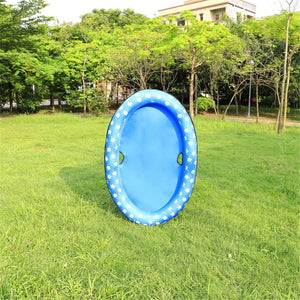 Blue inflatable ring on grass with trees and buildings in the background at Pet Servo