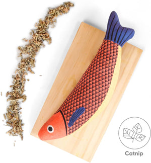 Wooden fish-shaped pet toy with red body and blue tail on a light wooden block, next to catnip at Pet Servo