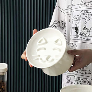 Person holding a white ceramic bowl with embossed design against a dark background at Pet Servo