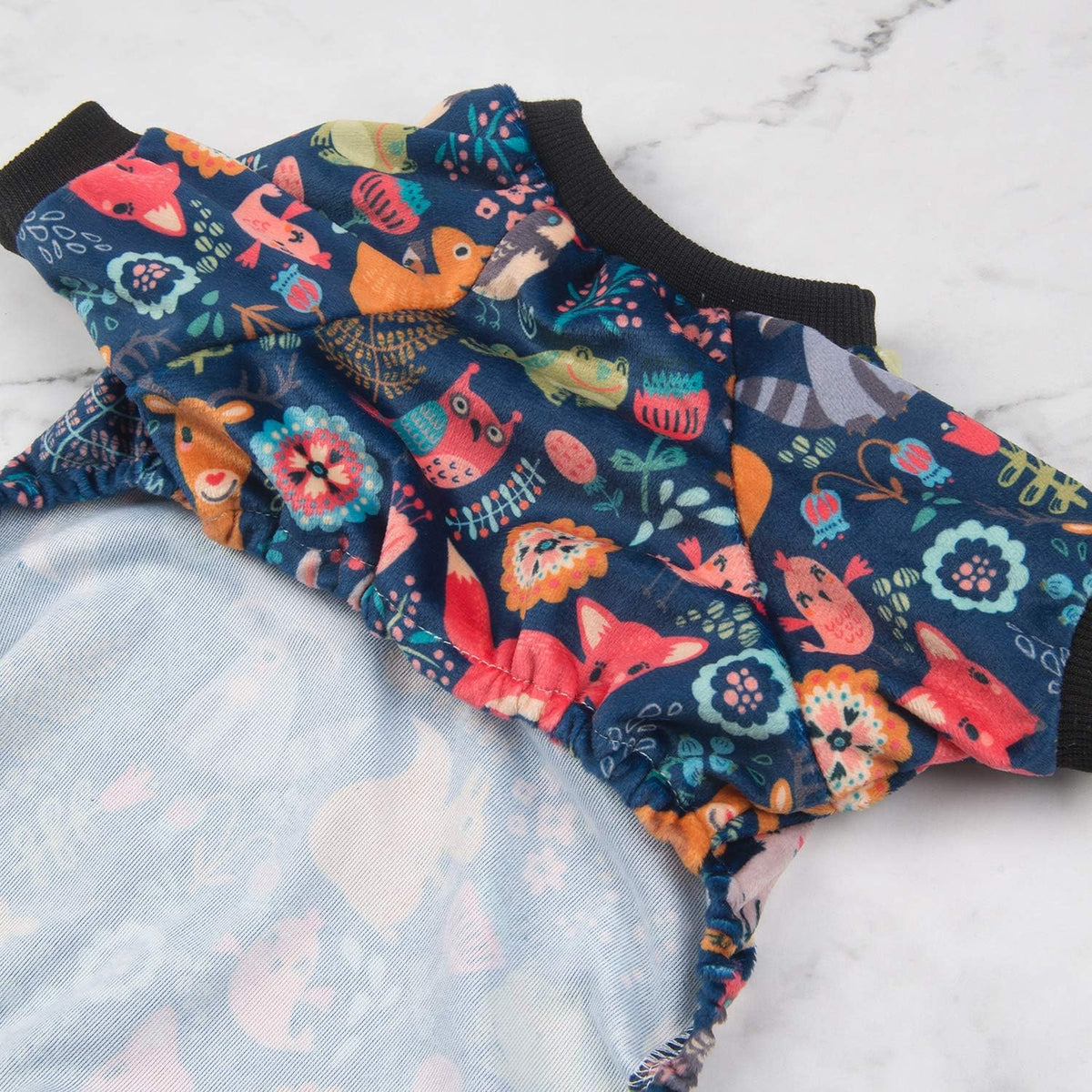 Colorful fabric with animal and floral patterns on a marble surface at Pet Servo