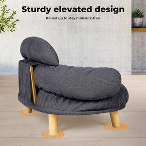Gray pet bed with wooden legs on a wooden floor, featuring text about a sturdy elevated design at Pet Servo