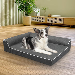 Dog lying on a gray pet bed in a room with wooden flooring and a plant at Pet Servo