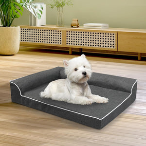 White dog lying on a gray pet bed in a room with wooden flooring and furniture at Pet Servo