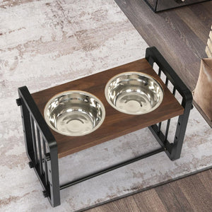 A two-bowl elevated pet feeder and waterer stand with a dark brown wooden top and a black metal frame, shown on a patterned rug over a wood floor at Pet Servo