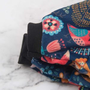 Colorful fabric with floral and bird patterns on a marble surface at Pet Servo