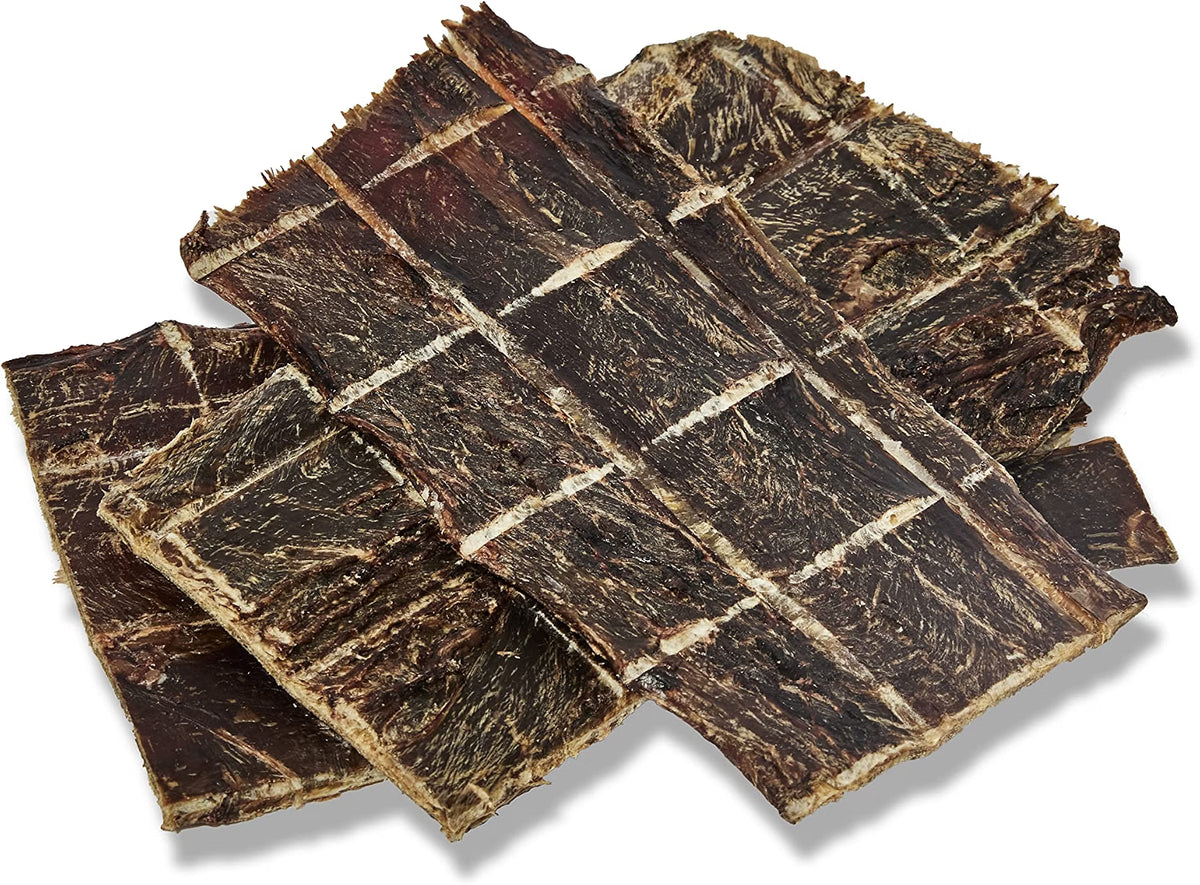 Several rectangular strips of dark brown dried jerky or beef jerky arranged overlapping on a white background with a soft drop shadow.