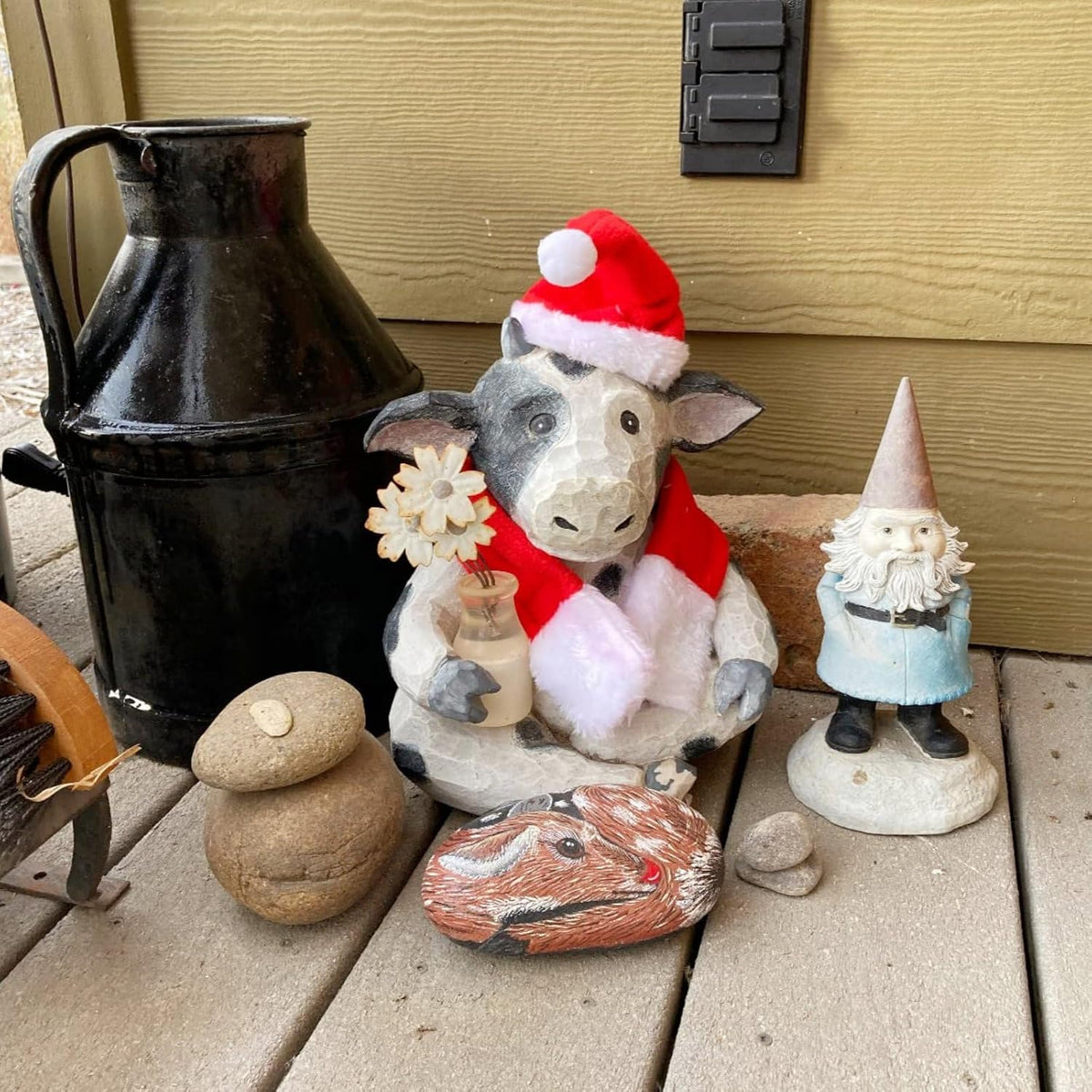 Decorative stone sheep with Santa hat and gnome on a wooden surface at Pet Servo