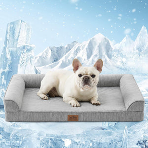 A white French Bulldog lies on a light gray textured pet bed with armrests, set against a snowy mountain background at Pet Servo