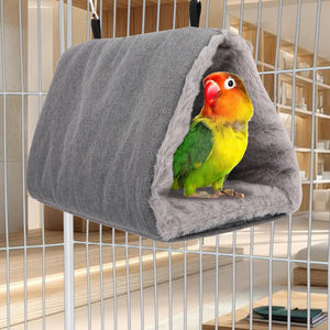 Colorful parrot inside a gray bird hammock attached to a cage at Pet Servo