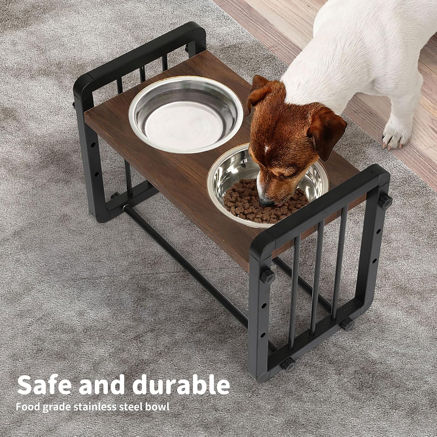 A small brown and white dog is eating from a stainless-steel bowl on a raised wooden pet feeder with a second empty bowl, placed on a gray carpeted floor. Text in the corner reads 'Safe and durable' and 'Food grade stainless steel bowl' at Pet Servo