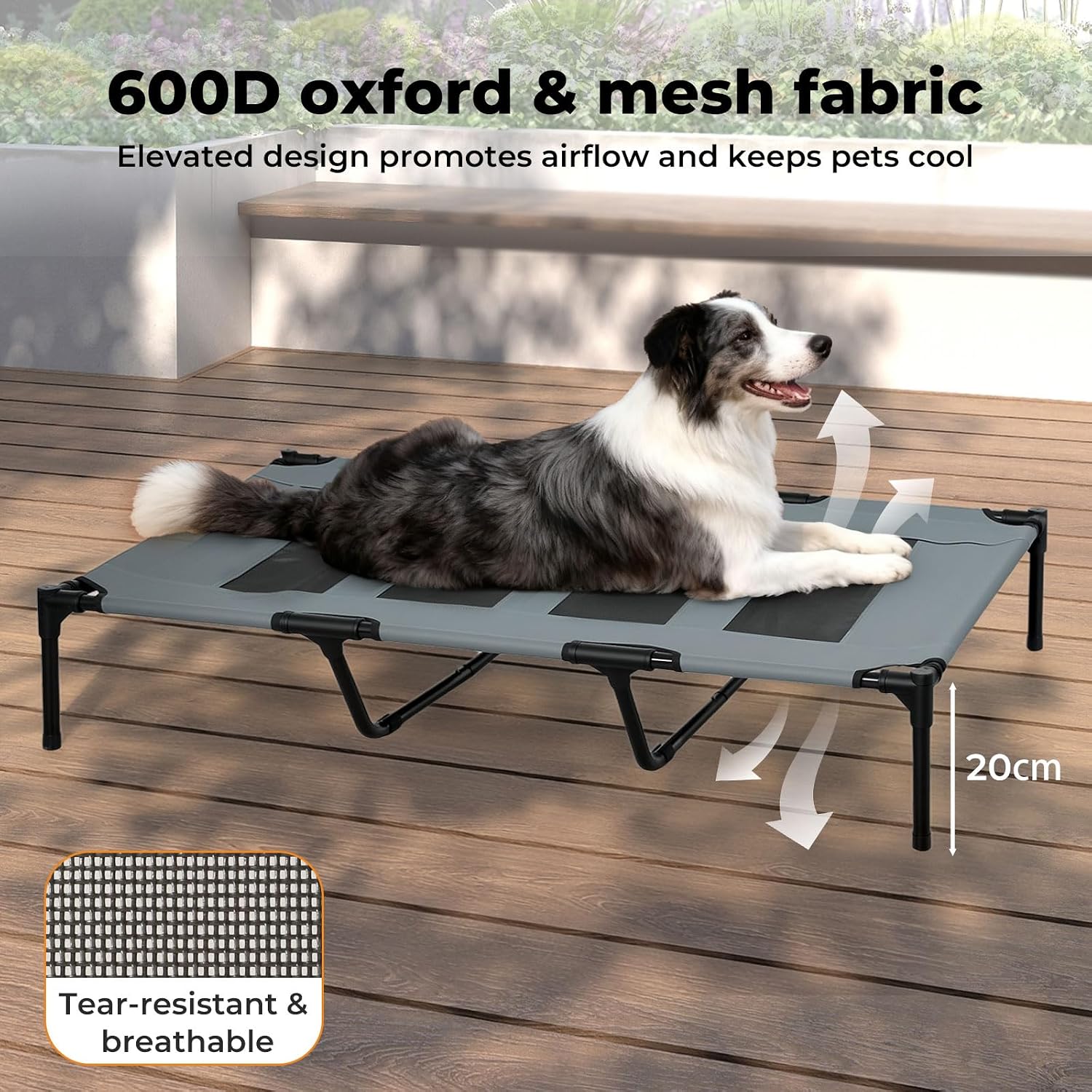 A black and gray elevated pet cot with a black metal frame, shown on a wooden deck with a black-and-white dog lying on it. Text at the top reads '600D oxford & mesh fabric' and 'Elevated design promotes airflow and keeps pets cool,' with arrows indicating airflow and a '20cm' height marker.