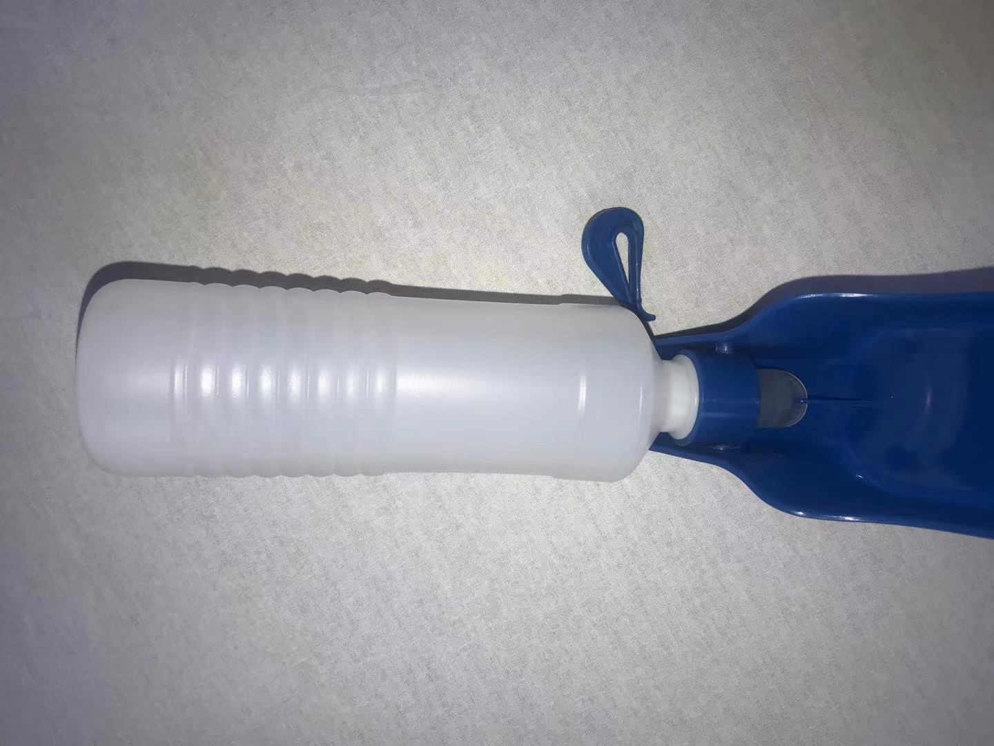 White bottle with blue cap on a gray surface at Pet Servo