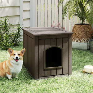 Dog sitting next to a wooden doghouse on grass at Pet Servo