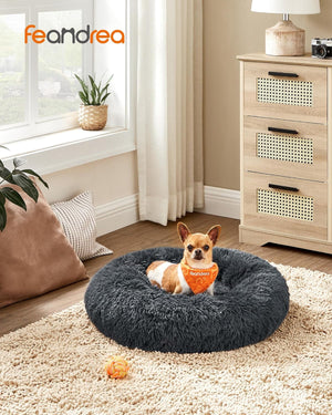 Dog lying on a fluffy gray pet bed in a cozy living room with 'feamdeea' branding at Pet Servo