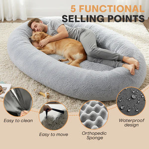 Person lying on a large gray pet bed with a dog, surrounded by text highlighting features at Pet Servo