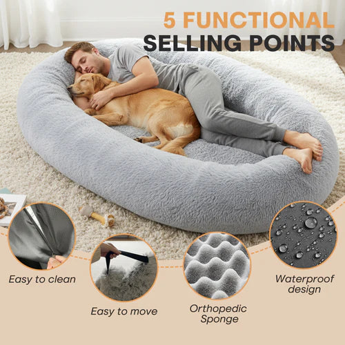 Person lying on a large gray pet bed with a dog, surrounded by text highlighting features at Pet Servo