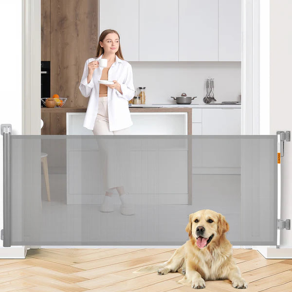 Woman in a kitchen with a dog standing behind a retractable pet gate.
