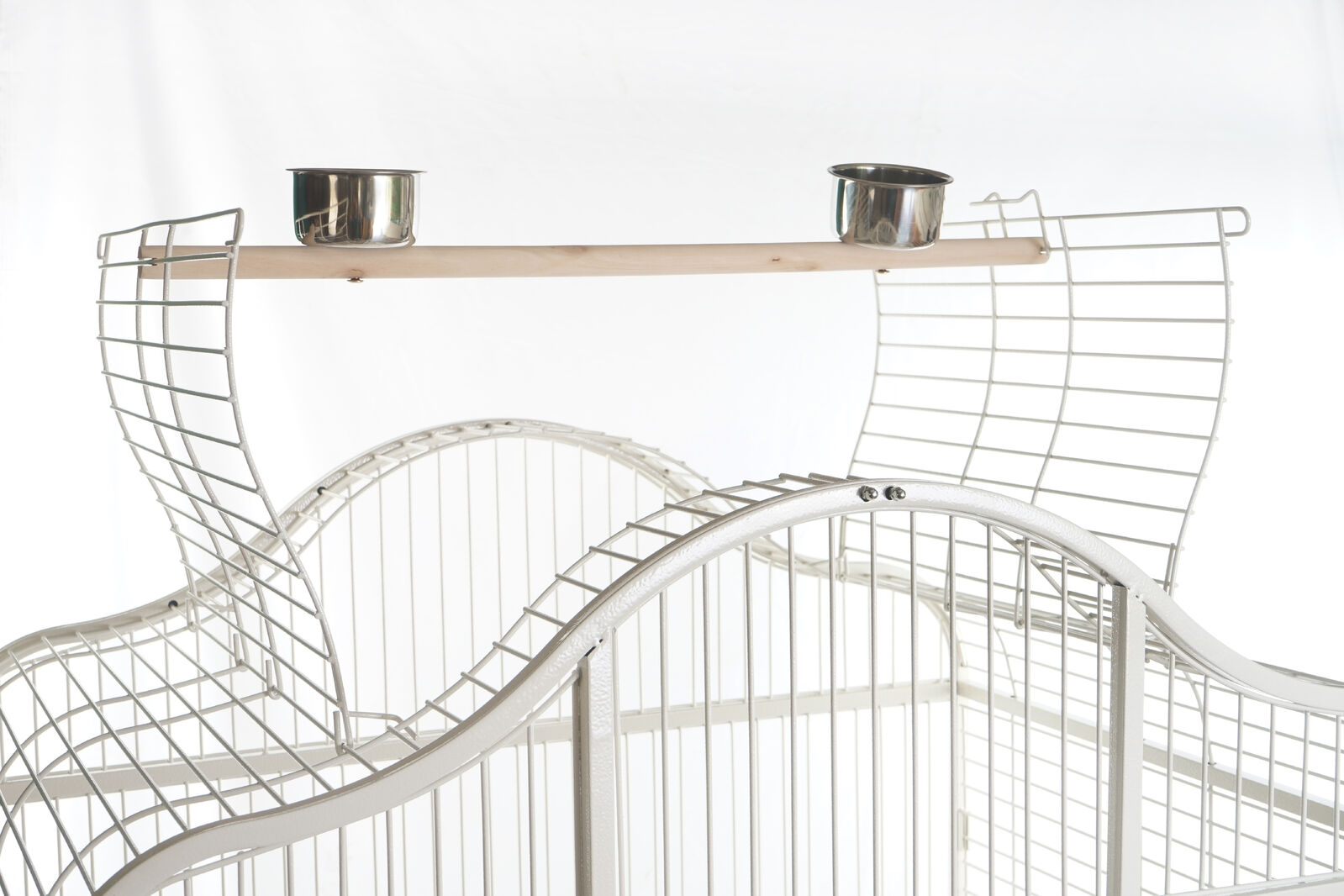 Wire pet cage with a wooden shelf and metal bowls on a white background at Pet Servo