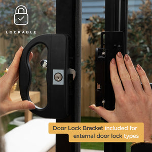 A close-up of a person's hands installing a black LOCKABLE door lock bracket onto a glass door frame, with an outdoor garden background visible through the window at Pet Servo