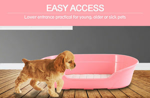 Pink pet litter box with a dog approaching it on a wooden floor at Pet Servo