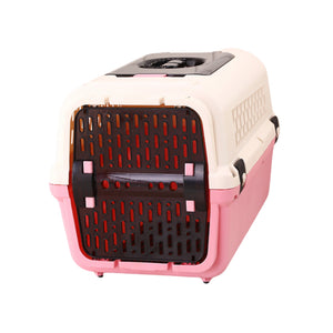A plastic pet carrier with a cream-colored top and sides, a pink bottom base, and a black front ventilation door with pink accents, shown on a plain white background at Pet Servo