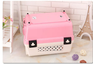 Pink pet carrier on a light wooden floor with decorative items at Pet Servo