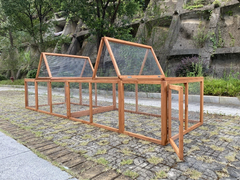 Wooden chicken coop on a stone path with trees and rocks in the background at Pet Servo