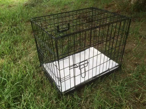 Black metal pet crate on grass at Pet Servo