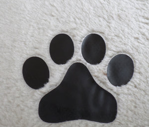 Black paw print on a textured white surface at Pet Servo