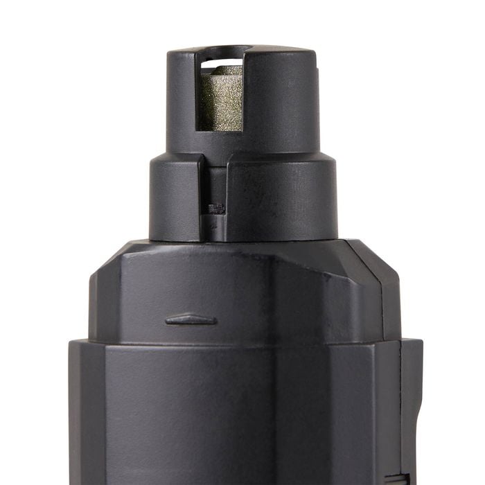 Close-up of a black cylindrical object with a textured top on a white background