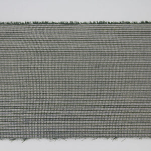 A close-up of a woven fabric or carpet sample with a tight gray and white crosshatch pattern and short dark green fibers visible along the top and bottom edges, shown against a plain white background at Pet Servo