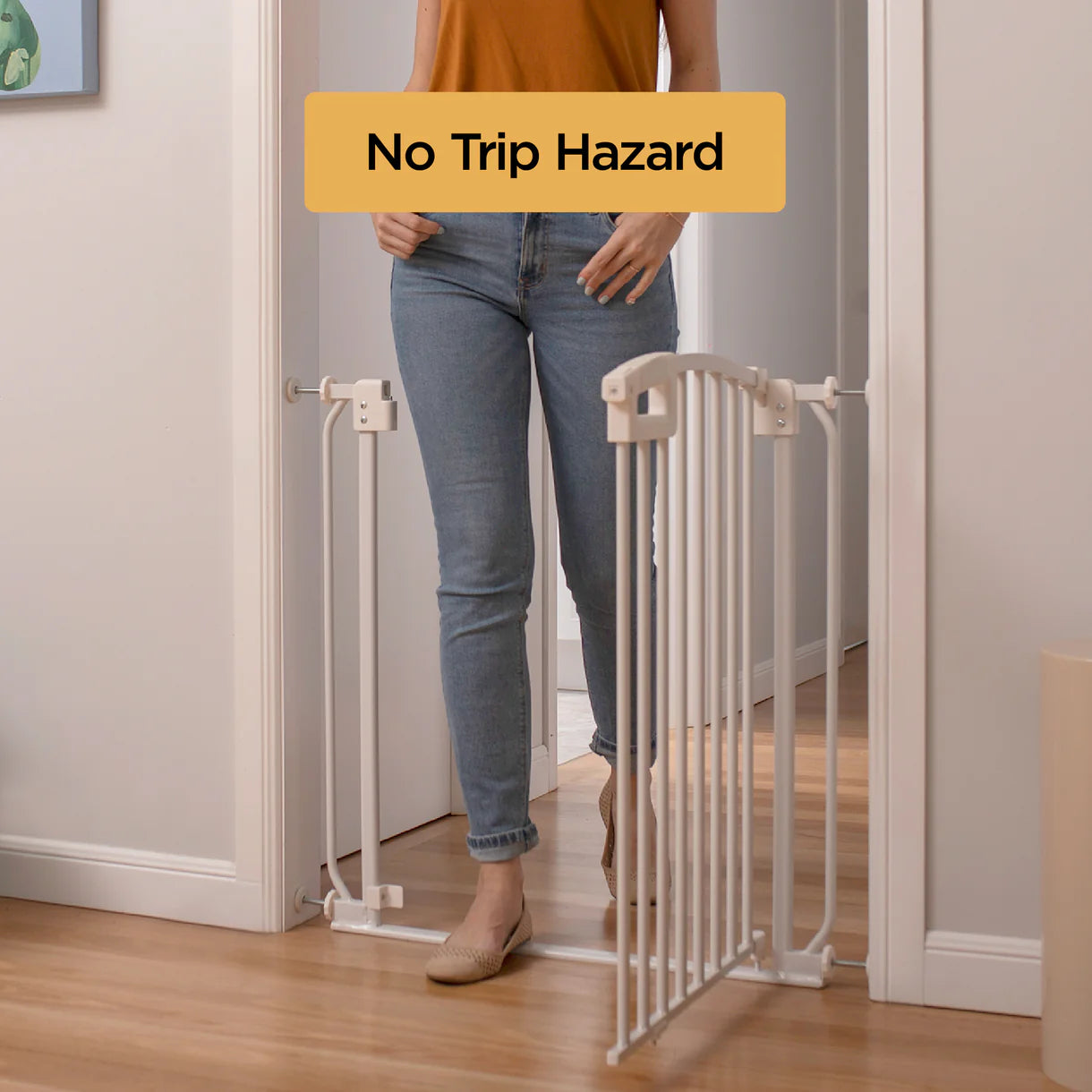 Woman using a baby gate with 'No Trip Hazard' text overlay in a home setting.