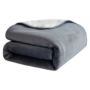 A folded plush fleece blanket in dark gray with a lighter gray sherpa lining, shown on a plain white background.