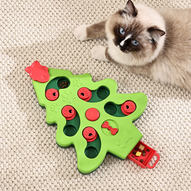 Green cat toy shaped like a Christmas tree with red accents on a beige carpet, next to a cat at Pet Servo