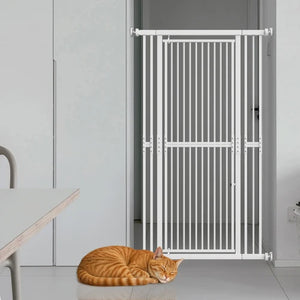 A white metal pet gate installed in a doorway, with an orange tabby cat sleeping on the floor in front of it. The scene is set in a clean, modern room with light gray walls and a white table partially visible on the left at PET SERVO