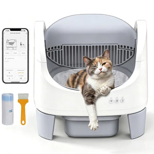 A white and gray automatic cat litter box with a calico cat lying inside, shown on a clean white background. A smartphone screen is visible on the left showing the app interface, along with two small accessories: a blue-lidded container and a yellow-handled brush at Pet Servo