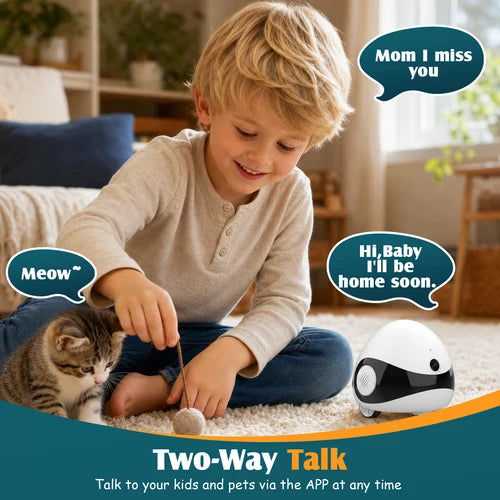 A young boy sits on a carpeted floor playing with a small white and black robotic toy next to a tabby kitten. Speech bubbles show the boy saying, 'Mom I miss you' and 'Hi, Baby I'll be home soon,' with text at the bottom reading 'Two-Way Talk' and 'Talk to your kids and pets via the APP at any time at Pet Servo