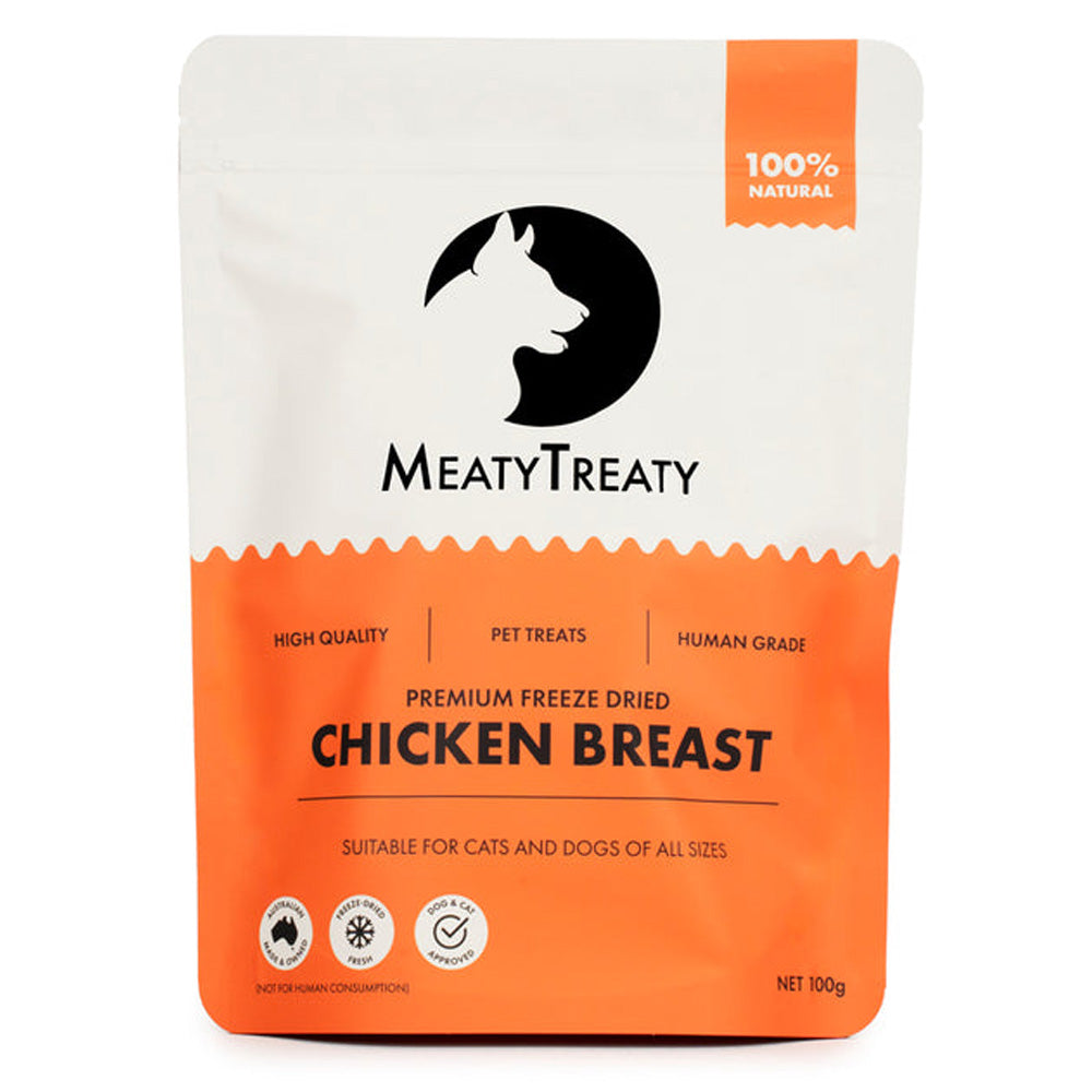 A stand-up pouch of MeatyTreaty Premium Freeze Dried Chicken Breast pet treats, featuring a white top half with a black cat silhouette logo and an orange bottom half.